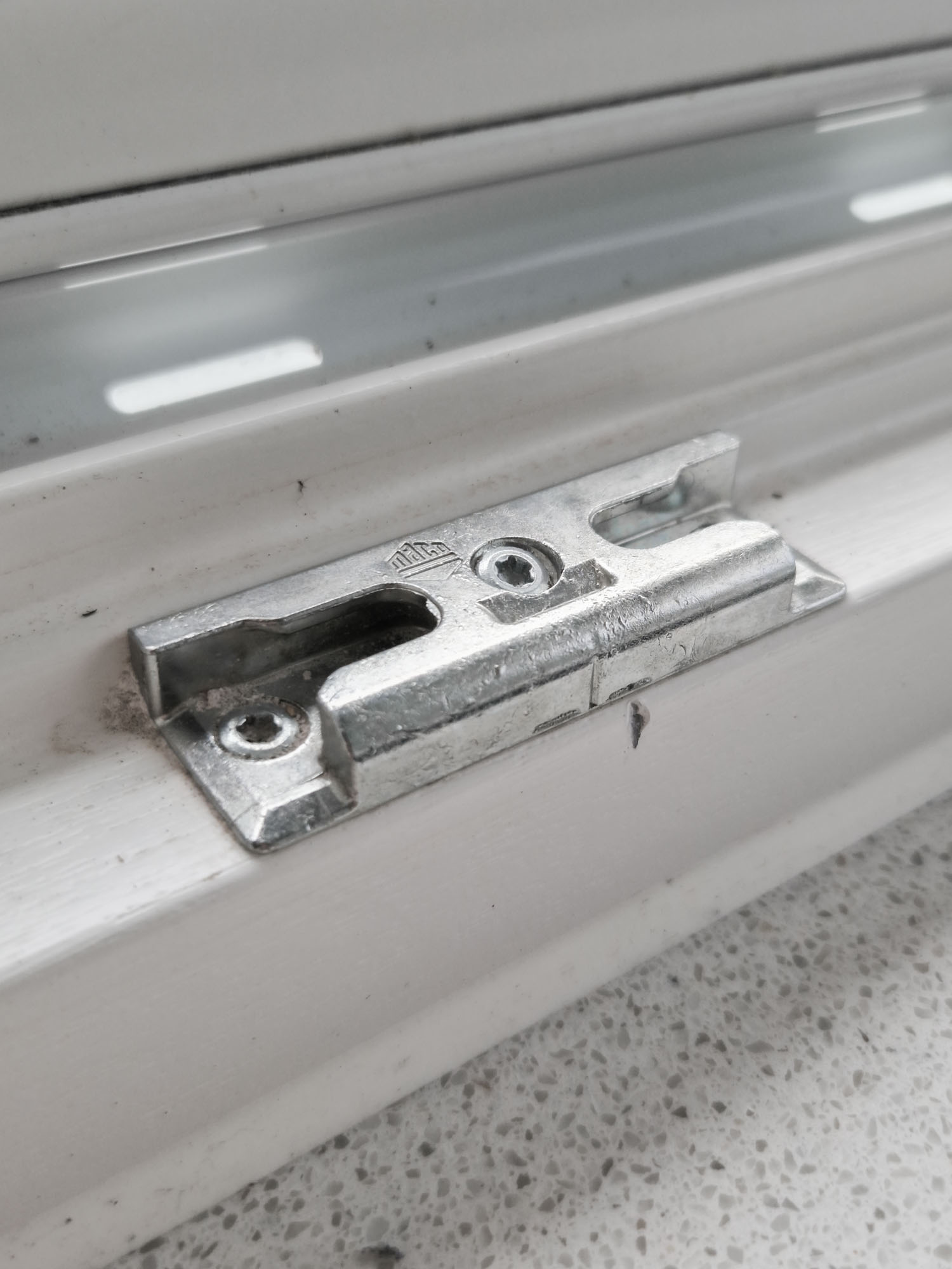 Nahaufnahme einer hochwertigen Türschließe aus Metall an einer geschlossenen Tür, fokussiert auf Mechanismus und Montagedetails.