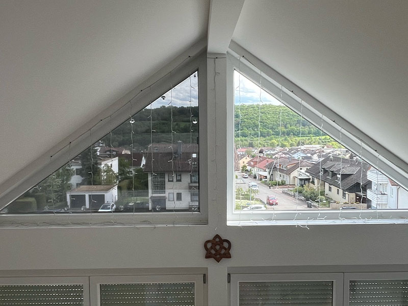 Vergleichsbild von zwei Dreiecksfenstern, eines mit Hitzeschutzverglasung und eines ohne, illustriert die Unterschiede in Wärmeschutz und Lichtdurchlässigkeit.